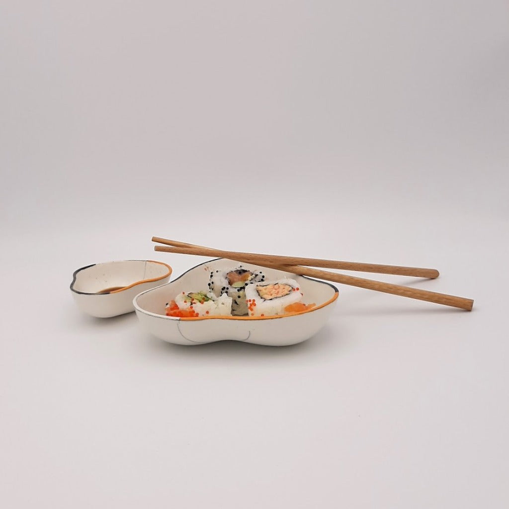 Kaolin - Guðný Magnúsdóttir - Sushi bowl, a set of two porcelain designed for three Sushi bites and the small one for the soya. Soft triangle form with white glaze, black and orange decoration.