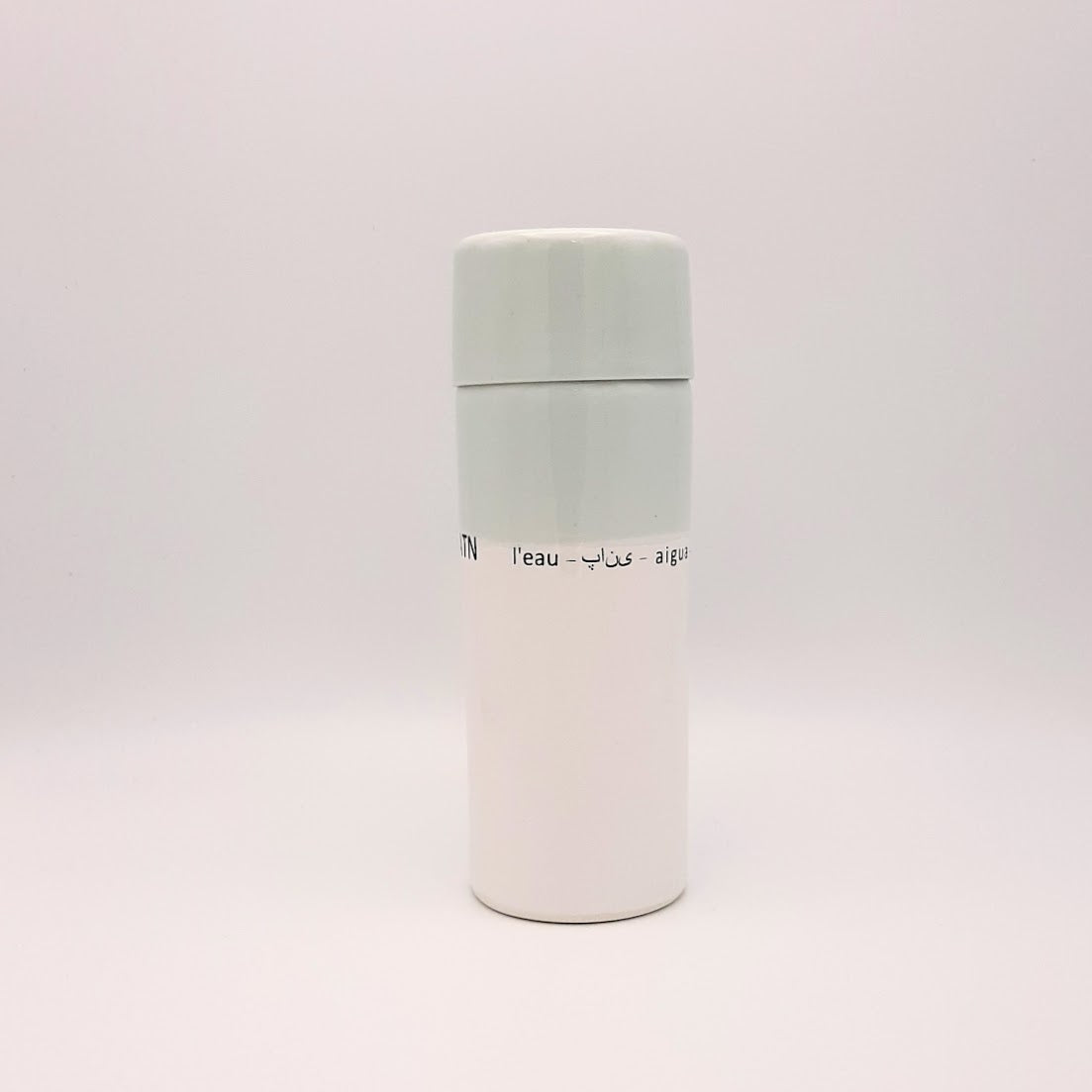 Kaolin - Guðný Magnúsdóttir - H2o WATER KARAFE - are designed in remembrance of the importance of water for all living creatures, the text says water in different languages. WATER - a water bottle in light blue and white glazes. The water bottle comes with a cap.
