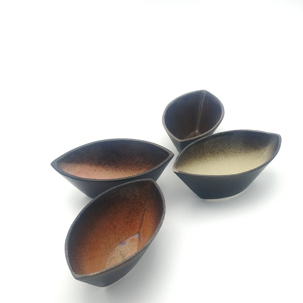 Kaolin-gudnyhaf-boats. Small boats glazed wiidth pink,blue,beige and orange on the inside and black on the outside.