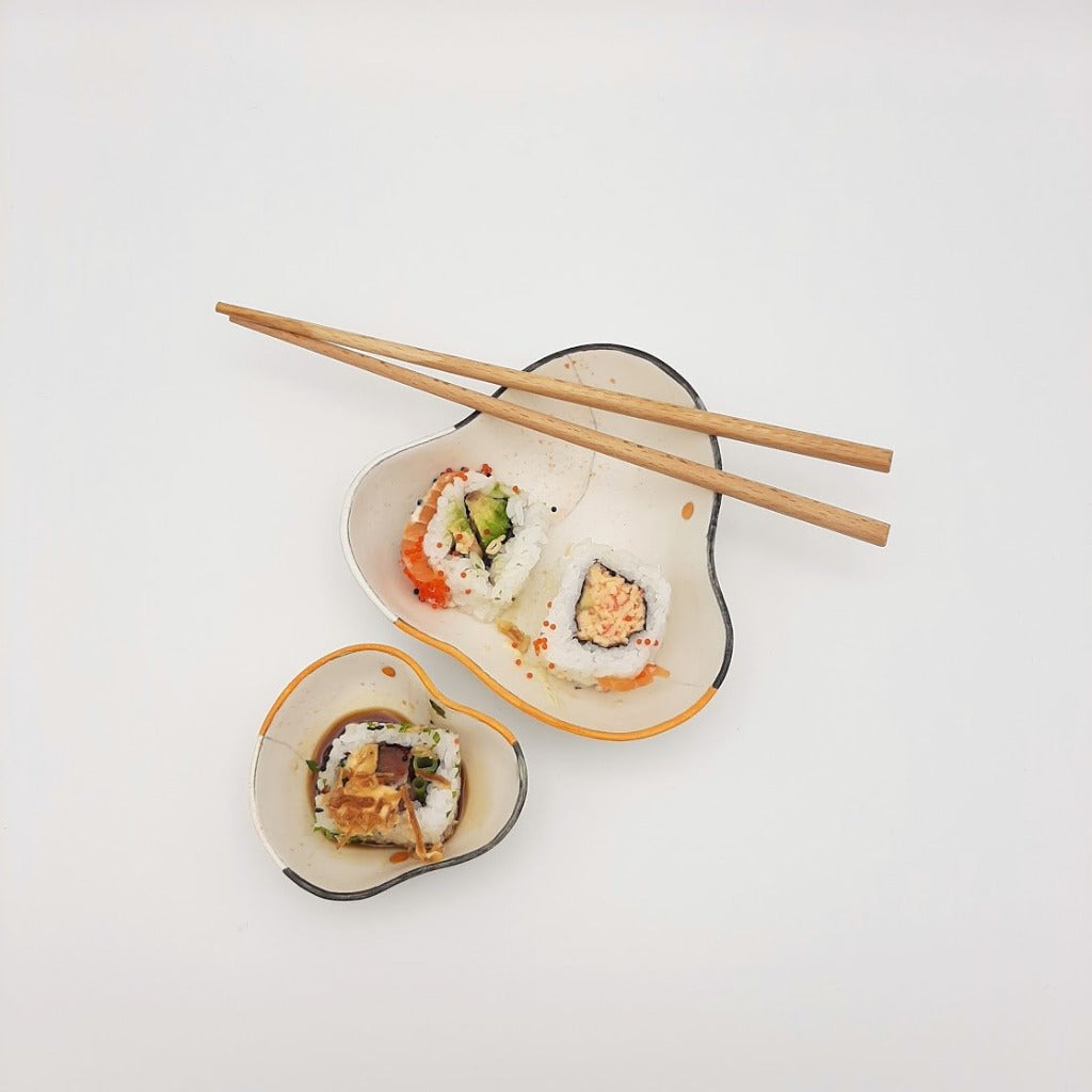 Kaolin - Guðný Magnúsdóttir - Sushi bowl, a set of two porcelain designed for three Sushi bites and the small one for the soya. Soft triangle form with white glaze, black and orange decoration.